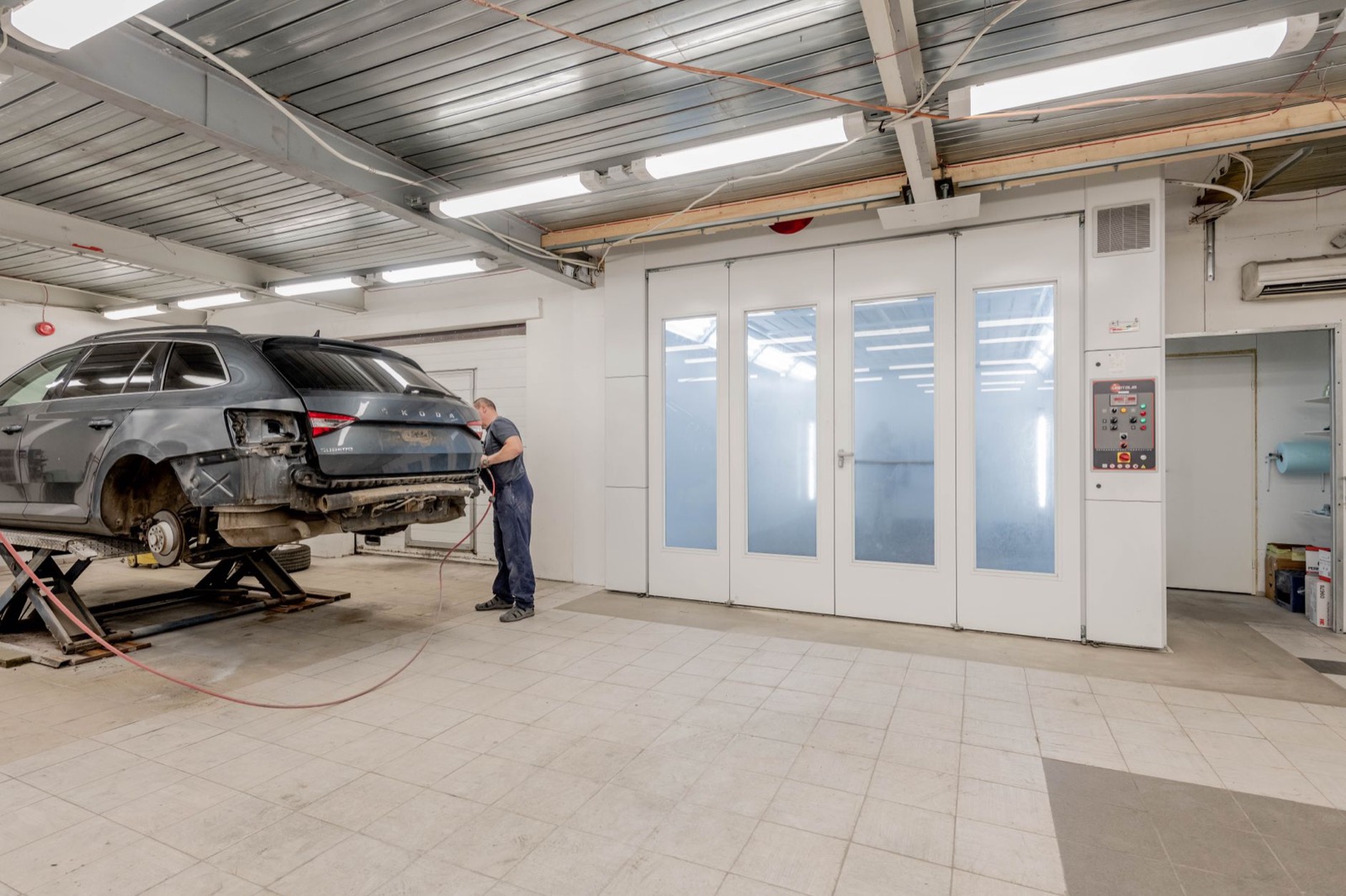 Mécanicien au travail à l'arrière d'une voiture dans un garage